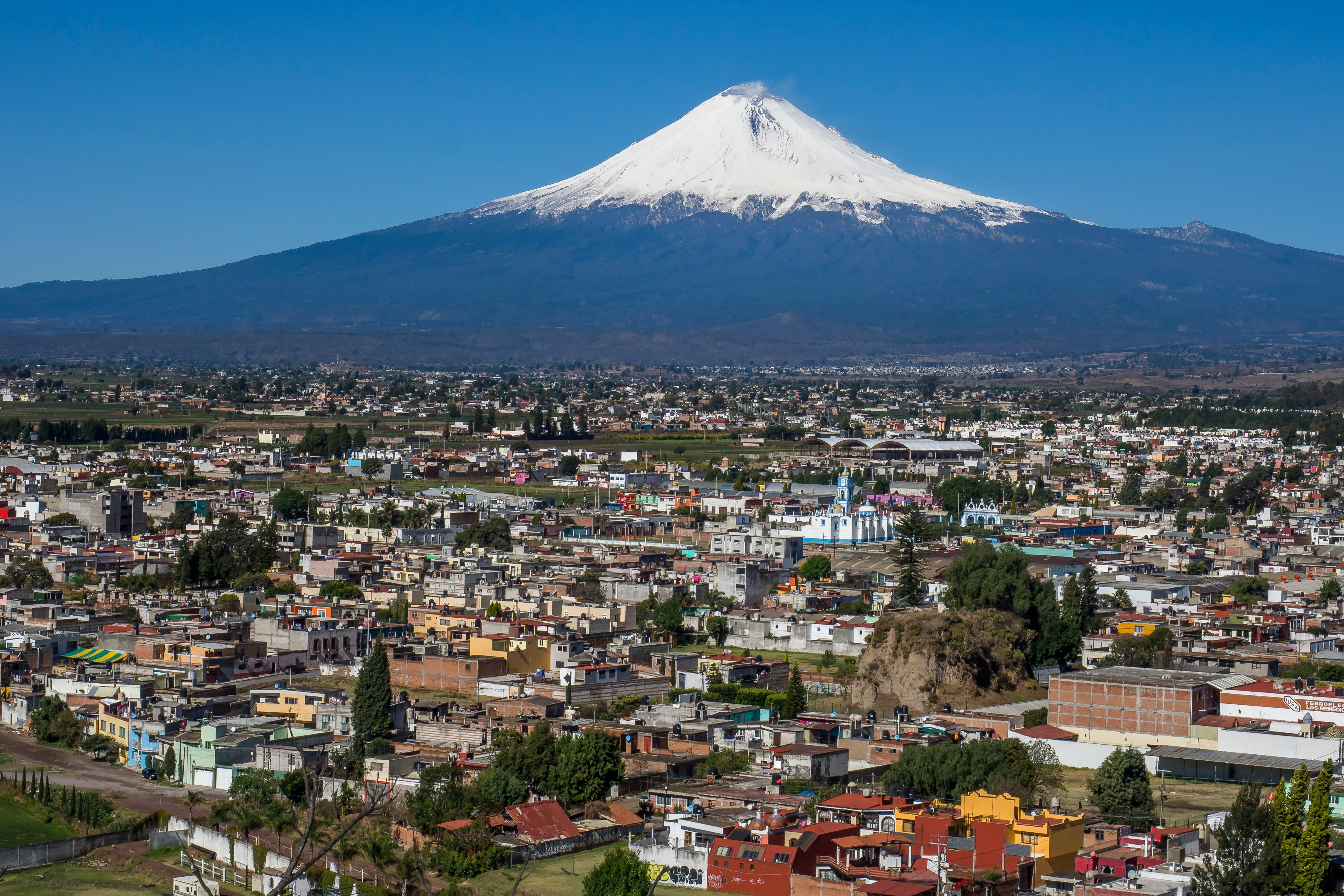 cityscape and volcano under blue sky